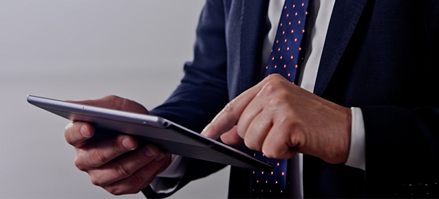 Close up of a man in a suit using a tablet