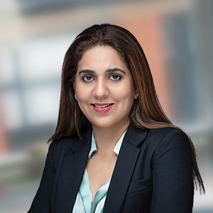 Headshot of Saira Nishtar wearing a black jacket looking at the camera