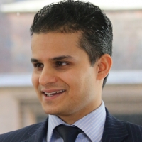 Head shot of Aman Sehgal smiling and looking away from camera