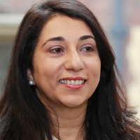 Head shot of Asha Kumar smiling and looking away from camera