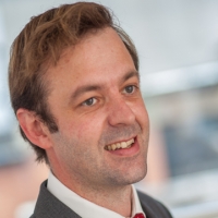 Head shot of Ben Crowley smiling and looking away from camera