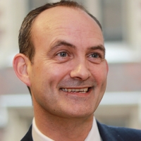 Head shot of Joe Haigh smiling and looking away from camera