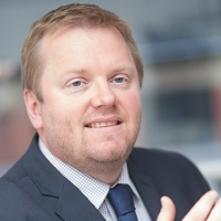 Head shot of Jon Close smiling and looking away from camera