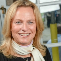 Head shot of Marie-Claire di Mambro smiling and looking away from camera