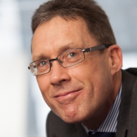 Headshot of Martin Howe wearing a suit looking away from the camera