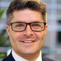 Head shot of Simon Holden smiling into camera