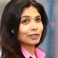 Head shot of Sofia Syed smiling and looking away from camera