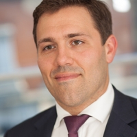 Head shot of William Margot in a suit looking away from camera