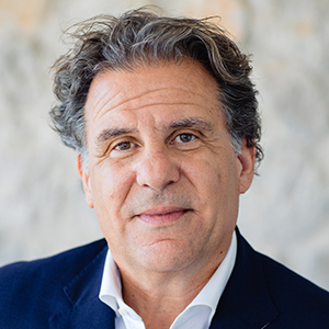 Headshot of George Lambrou wearing a suit looking at the camera