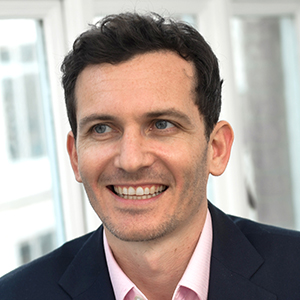 Headshot of Richard Abrahams wearing a suit looking away from the camera