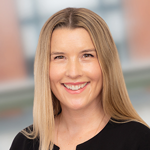 Headshot of Suzy Schmitz wearing black looking directly into the camera