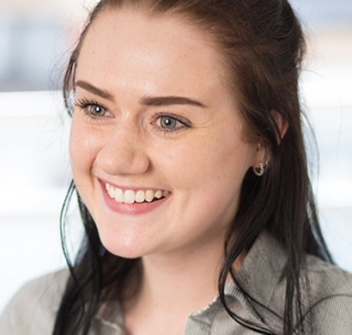 Head shot of Niamh Courtaux looking away from camera and smiling
