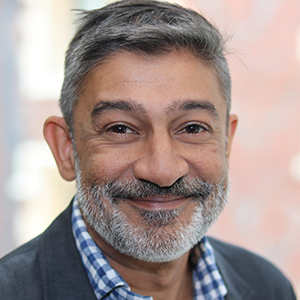 Head shot of Sal Mamujee smiling into camera