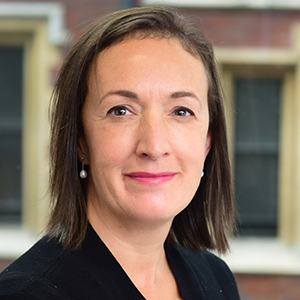 Headshot of Rowan Brown wearing pearl earings looking at the camera