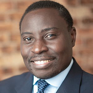 Head shot of Henry Kikoyo smiling into camera