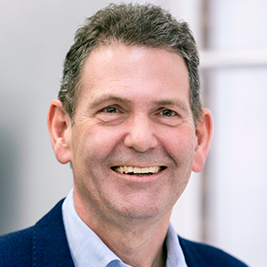 Head shot of Adam Perry smiling and looking away from camera