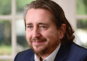 Head shot of Simon Chalkley smiling and looking away from camera