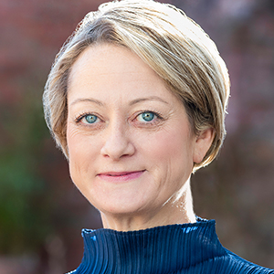 Headshot of Ali Jones wearing a blue top looking above the camera