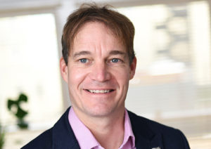 Head shot of Guy Hitchin smiling and looking away from camera