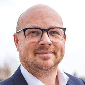 Head shot of Jon Olson-Welsh smiling and looking away from camera